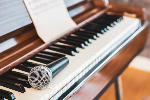 istock microphone on piano keys. music background 1300081215