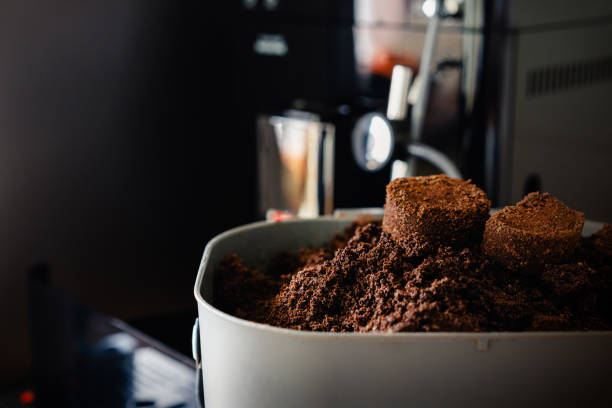 istock Used coffee grounds from espresso machine. Recycling compost container filled with used coffee waste. Coffee machine cleaning. 1300081404