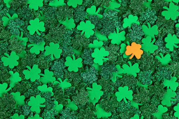 istock Shamrock confetti texture background with green and orange lucky clovers 1300081433