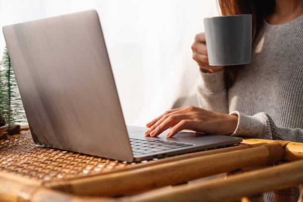 istock a young woman using and working on laptop computer while drinking coffee at home 1300082415