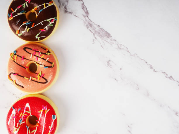istock donuts in a row on a marble background, a copy of the space 1300083195