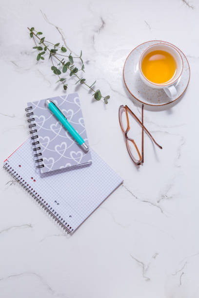istock Flat lay home business desk -  cup of tea, with communication device with and writing tools 1300089285