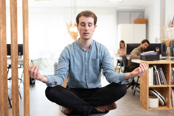 istock Man meditating in the office 1300089290