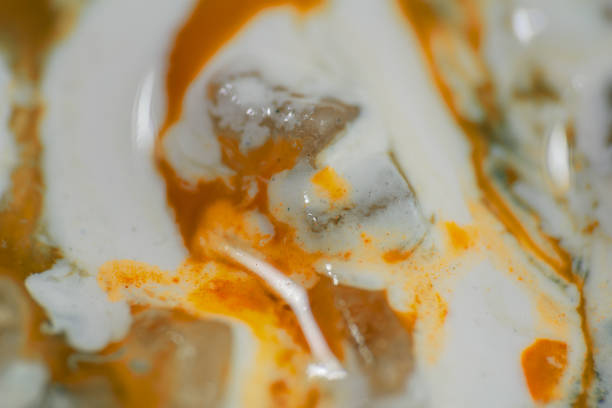 Luqiud vivid orange color mixing together on white background. Painting, splash marble abstract texture