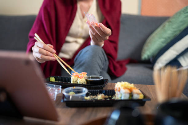 mulher tendo takeaway ou entrega sushi rola refeição de um pacote plástico com molhos em casa - chopsticks human hand women isolated - fotografias e filmes do acervo