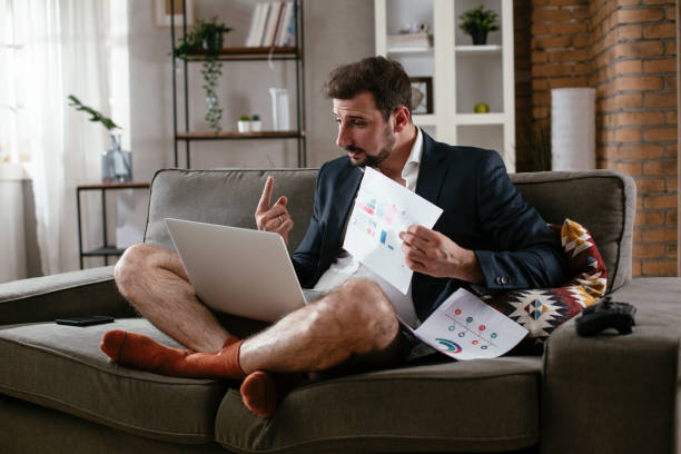 istock Young man working online, wearing suit and no pants. 1300100912