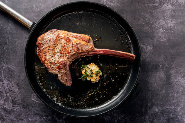 tomahawk steak em uma panela griddle - rib steak - fotografias e filmes do acervo