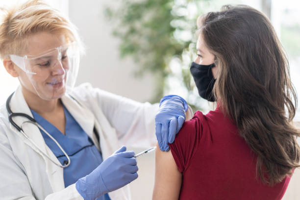 istock Vaccinating a young woman in doctors's office 1300101073