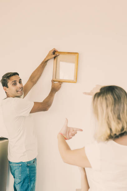 istock Happy man in casual clothes hanging up frame with copy space 1300102537