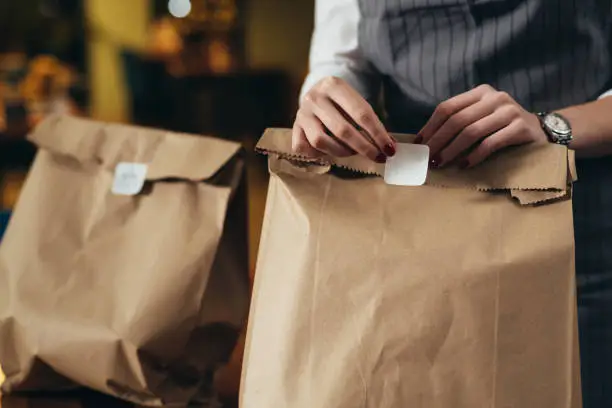 woman waitress preparing take away food in restaurant