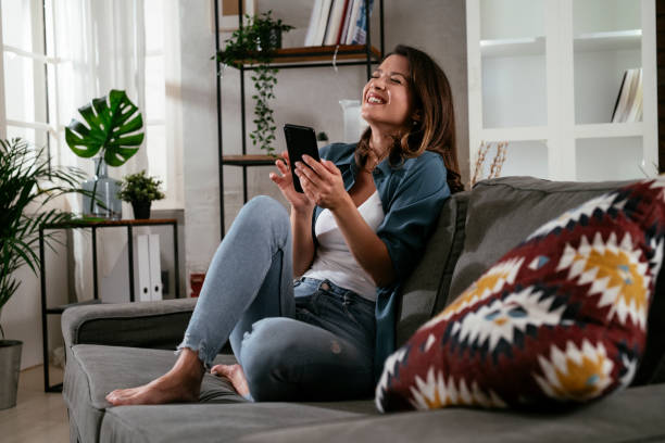 istock Happy young woman using the phone at home. 1300104719
