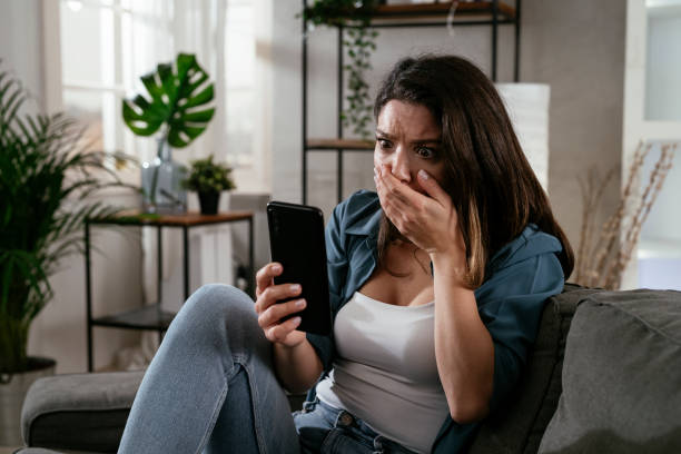 istock Sad woman sitting on the couch, using the phone 1300104881