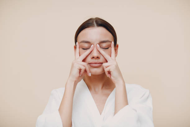 young woman doing face building facial gymnastics self massage and rejuvenating exercises - face mask imagens e fotografias de stock