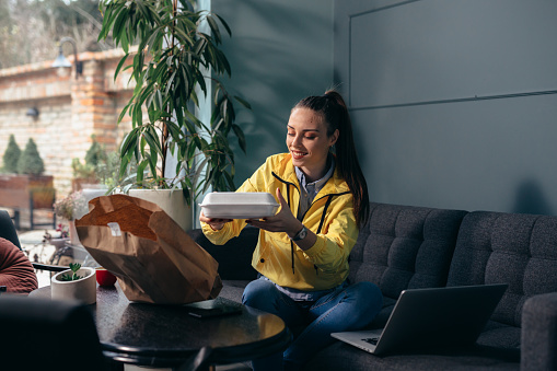 woman eating take away food , in her home