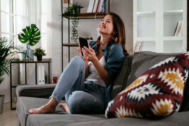 istock Happy young woman using the phone at home. 1300105170
