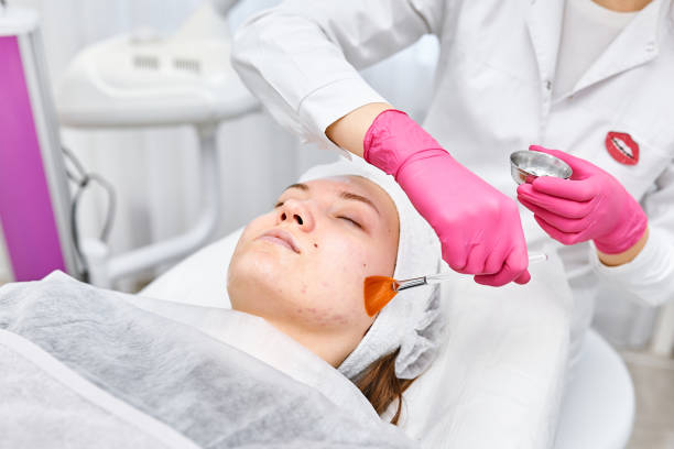 Portrait Cosmetologist applying mask on client's face in spa salon. Wellness center. Healthcare occupation Cosmetologist applying mask on client's face in spa salon. Wellness center. Healthcare occupation facial chemical peel stock pictures, royalty-free photos & images