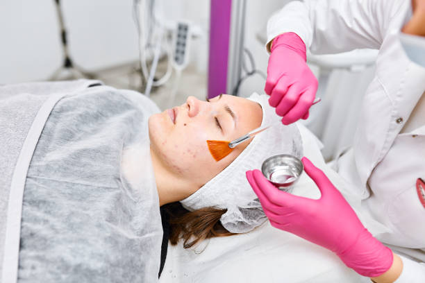 Portrait Cosmetologist applying mask on client's face in spa salon. Wellness center. Healthcare occupation Cosmetologist applying mask on client's face in spa salon. Wellness center. Healthcare occupation facial chemical peel stock pictures, royalty-free photos & images