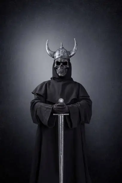 Skeleton warrior with horned helmet and sword in the dark