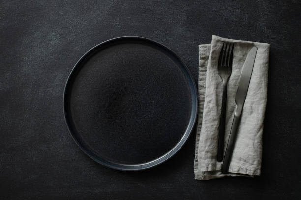 istock Empty black plate with cutlery and napkin. 1300107751