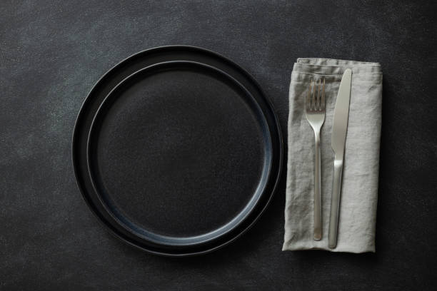 istock Empty black plates with cutlery and napkin. 1300107758