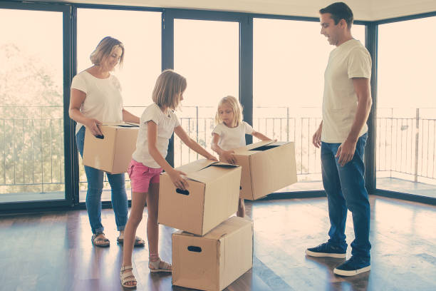 istock Smiling mother with kids holding cardboard boxes 1300107863