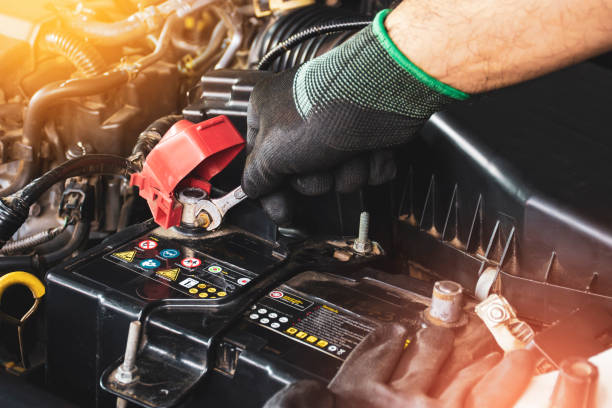 la mano mechanic è fissata il bullone con la chiave open-end - battery replacement foto e immagini stock