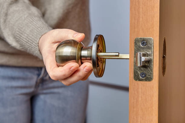 istock Doorknob in hand of carpenter during installation. 1300109236