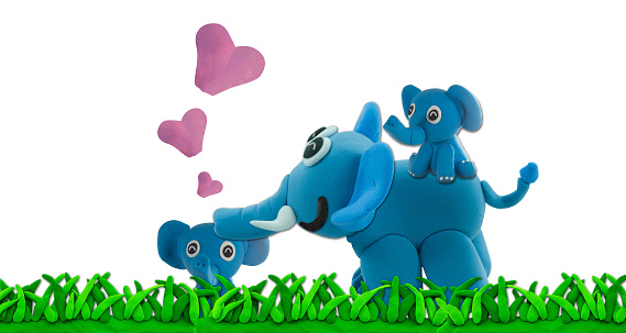 plasticine elephant and son on green grass in concept wild nature and family on white
