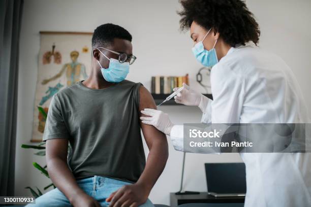 Young African American Man Taking Covid 19 Vaccine Stock Photo - Download Image Now - Vaccination, COVID-19 Vaccine, African-American Ethnicity