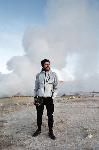 Man is standing in front of Sol de Mañana a geothermal area in Sur Lípez Province in the Potosi Department of south-western Bolivia