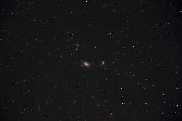 M81 and M82 galaxies in Ursa Major constellation photographed with long exposure through a telescope.