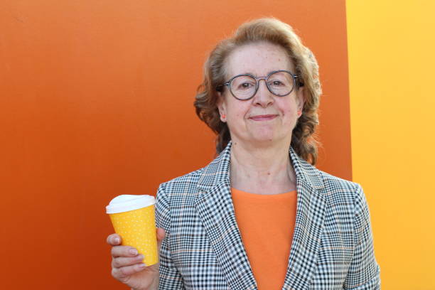 istock Middle aged woman holding coffee to go 1300113468