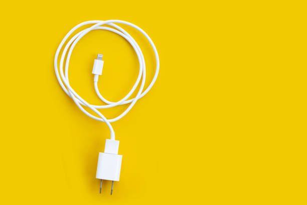 istock Mobile phone charger on yellow background. 1300117936