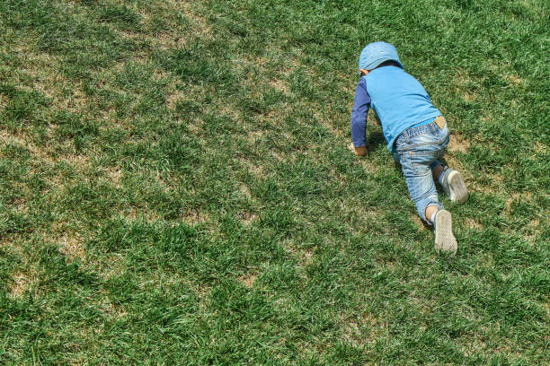 istock Playful boy goes up steep hill covered with lush grass 1300120033
