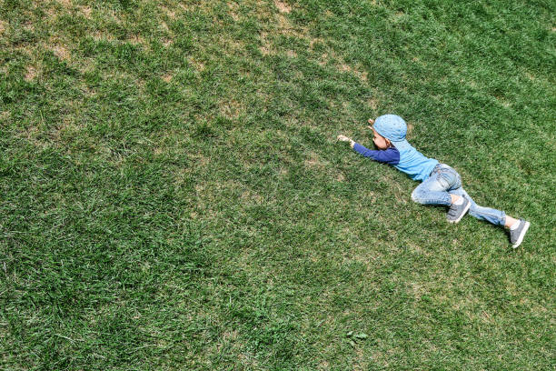 istock Playful boy goes up steep hill covered with lush grass 1300120121