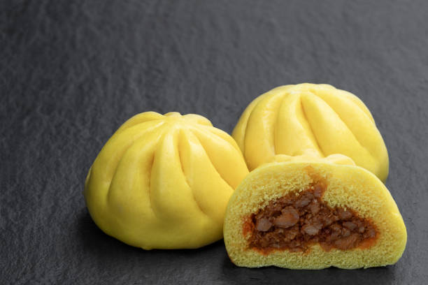 Steamed honey chicken and duck bao buns on stone background