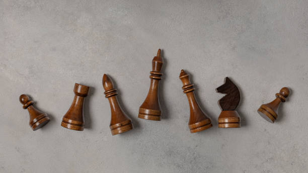 istock Black chess pieces in a row on a light background 1300122942