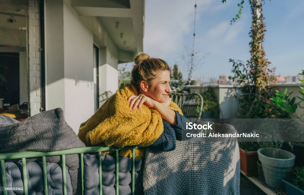 Relaxing morning on my terrace Photo of a young woman having a relaxing start of a day on her terrace, soaking in the first springtime sun Sun Stock Photo