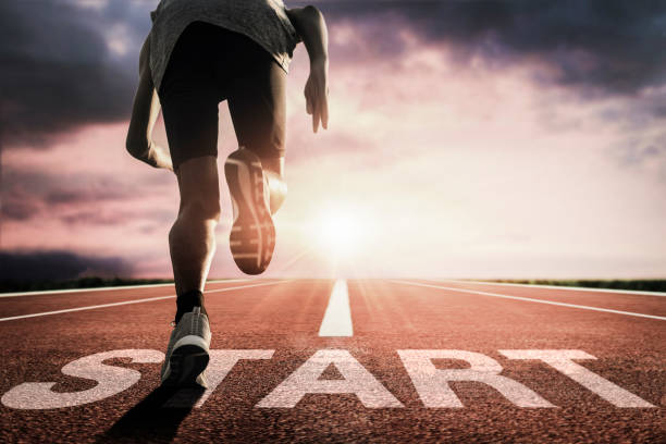 runners running from the starting on the running track - beginnings imagens e fotografias de stock