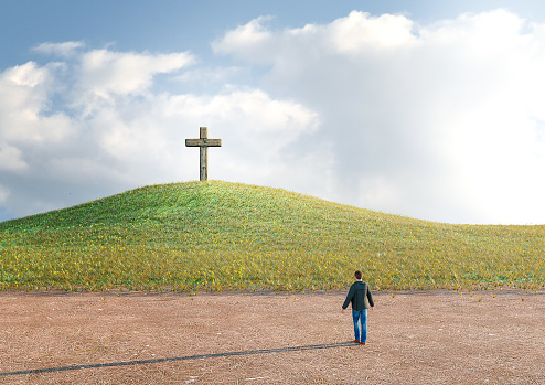 man in the desert seeking salvation by faith in Jesus Christ looking at the cross. 3D rendering