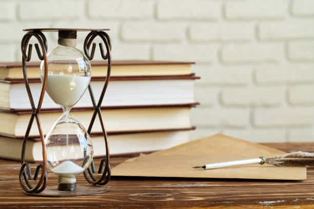 istock Vintage hourglass against a stack of old books 1300125100