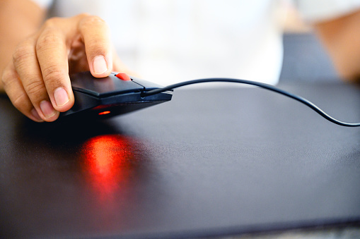 Close-up image of Business man's hands using a mouse and keyboard computer.