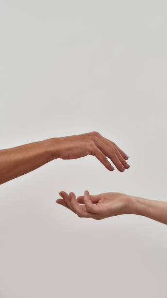 istock Close up of two open cupped hands with empty space between them isolated over light background 1300129596