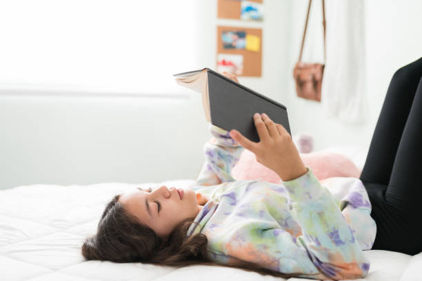 istock Adolescent girl reading and studying in her bedroom 1300129634