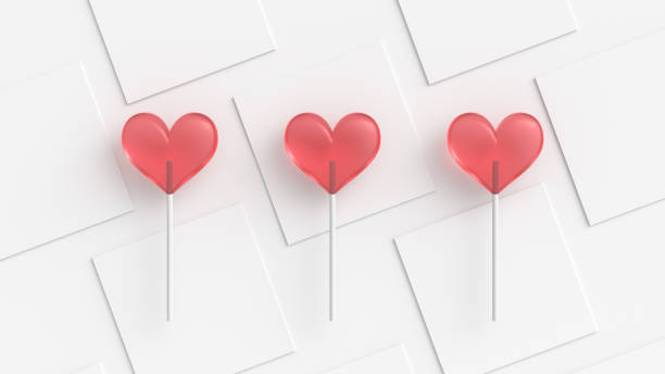 istock Red hearts candy on stick with minimal white background, top view 1300132354