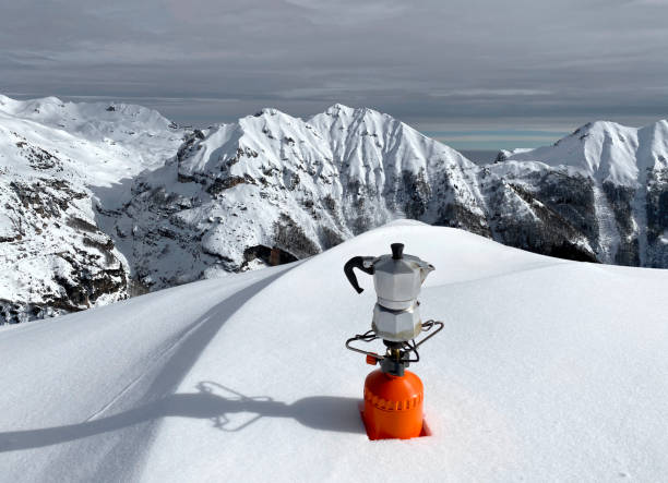 moka die zich op het gasfornuis in de sneeuwberg bevindt - cafe snow stockfoto's en -beelden