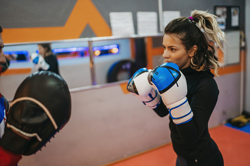 Personal trainer working with  client at a gym