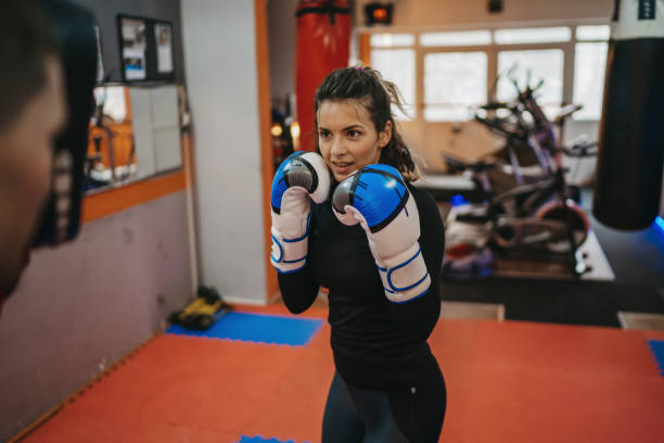 istock Female kickboxer practicing with her personal trainer in a gym 1300135863