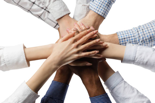 istock Group of people putting hands together isolated over white background. 1300136038