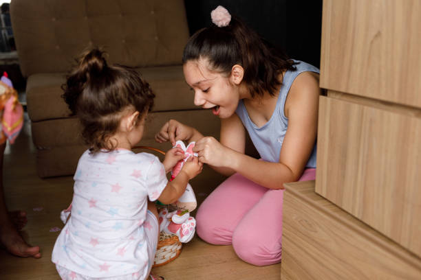 istock Two sisters playing with plush rabbit toy 1300136265